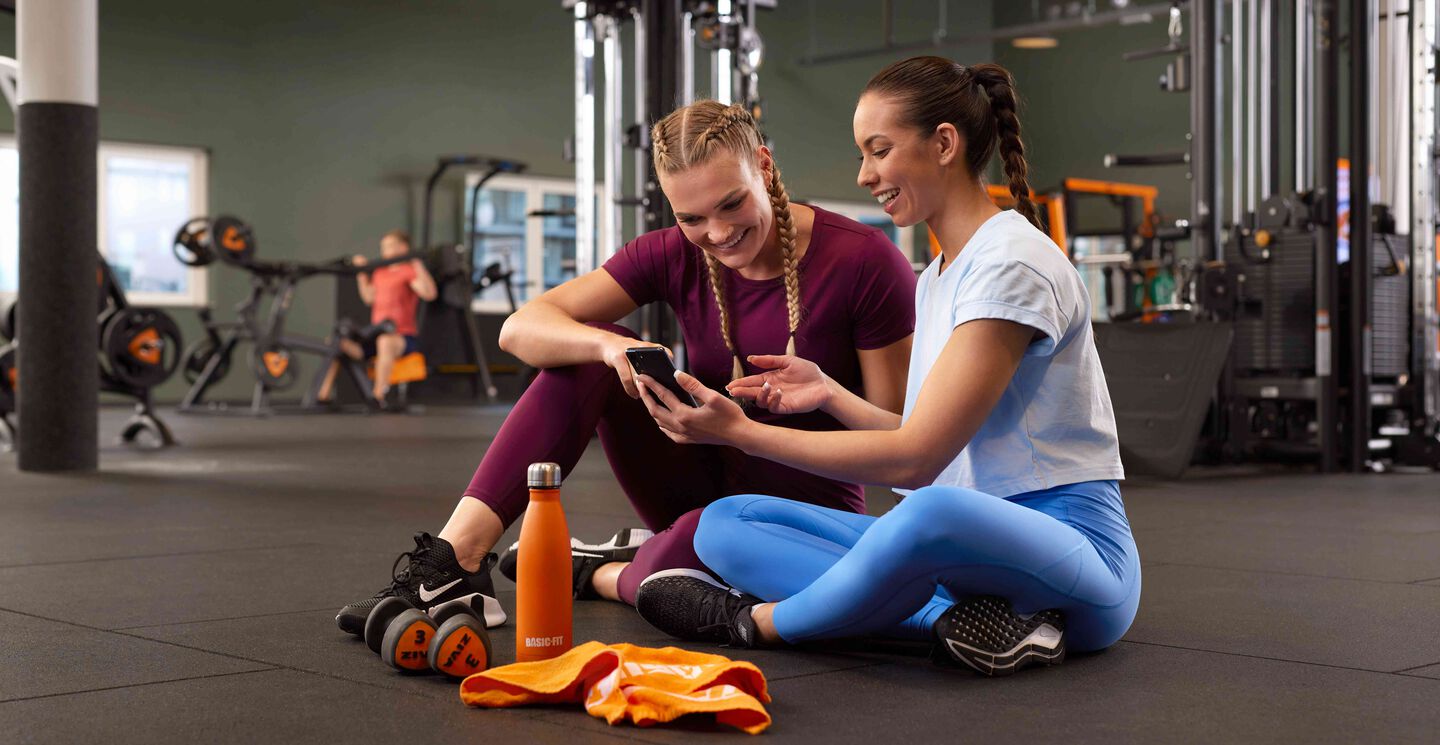 Two ladies checking out the Basic-Fit app